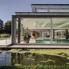 A  Contemporary Villa in Belgium Comes Complete With a Landscape Pond and Showroom Garage